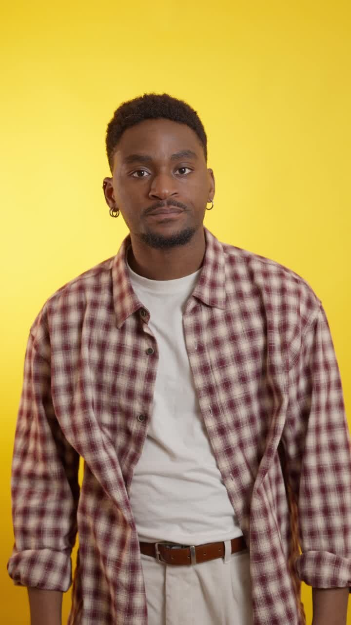Man in plaid shirt with yellow background