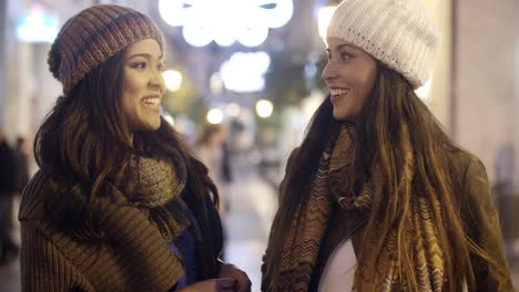 Two-young-woman-chatting-outdoors-in-winter