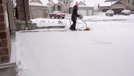 senior woman shoveling snow from her driveway