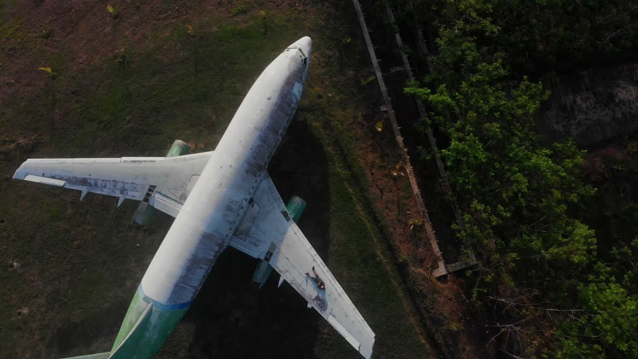 Luftfoto af et gammelt forladt fly på en landlig mark i blødt morgenlys i Jembrana, Bali, Indonesien
