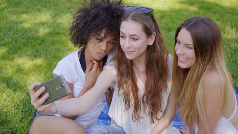 chicas guapas tomando selfie en el césped