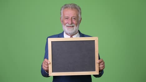homem de negócios barbudo e bonito contra um fundo verde.