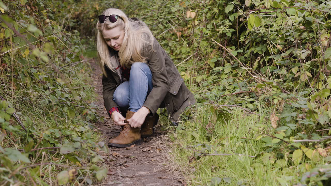 mujer atando cordones de zapatos al aire libre