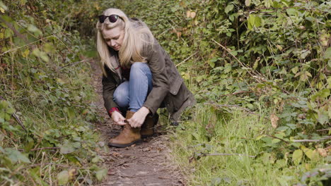 woman tying shoelaces outdoors