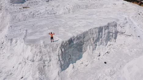 shirtless sportman op de rotsachtige canyon. luchtbeeld van een sterke man die poseert op de top van de heuvel in de zomer. natuurlijke bergachtige achtergrond.