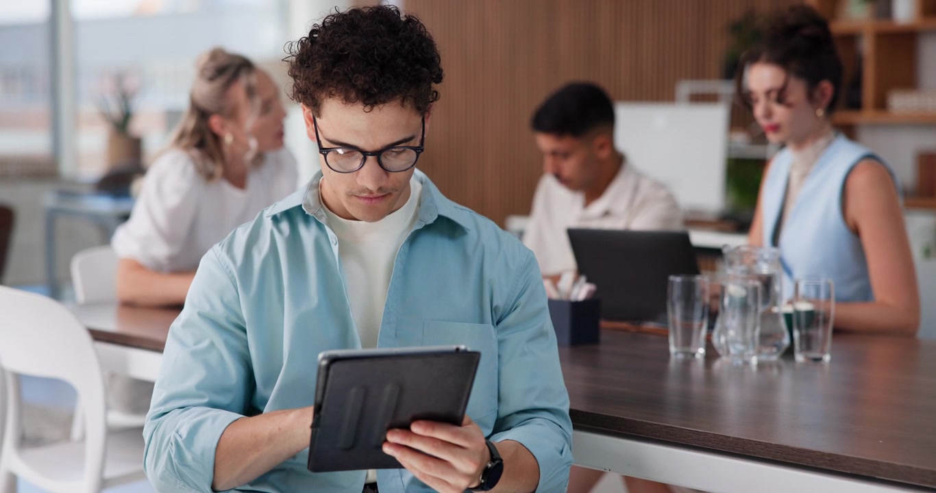 Young Man Using Digital Tablet in Modern Office Workspace