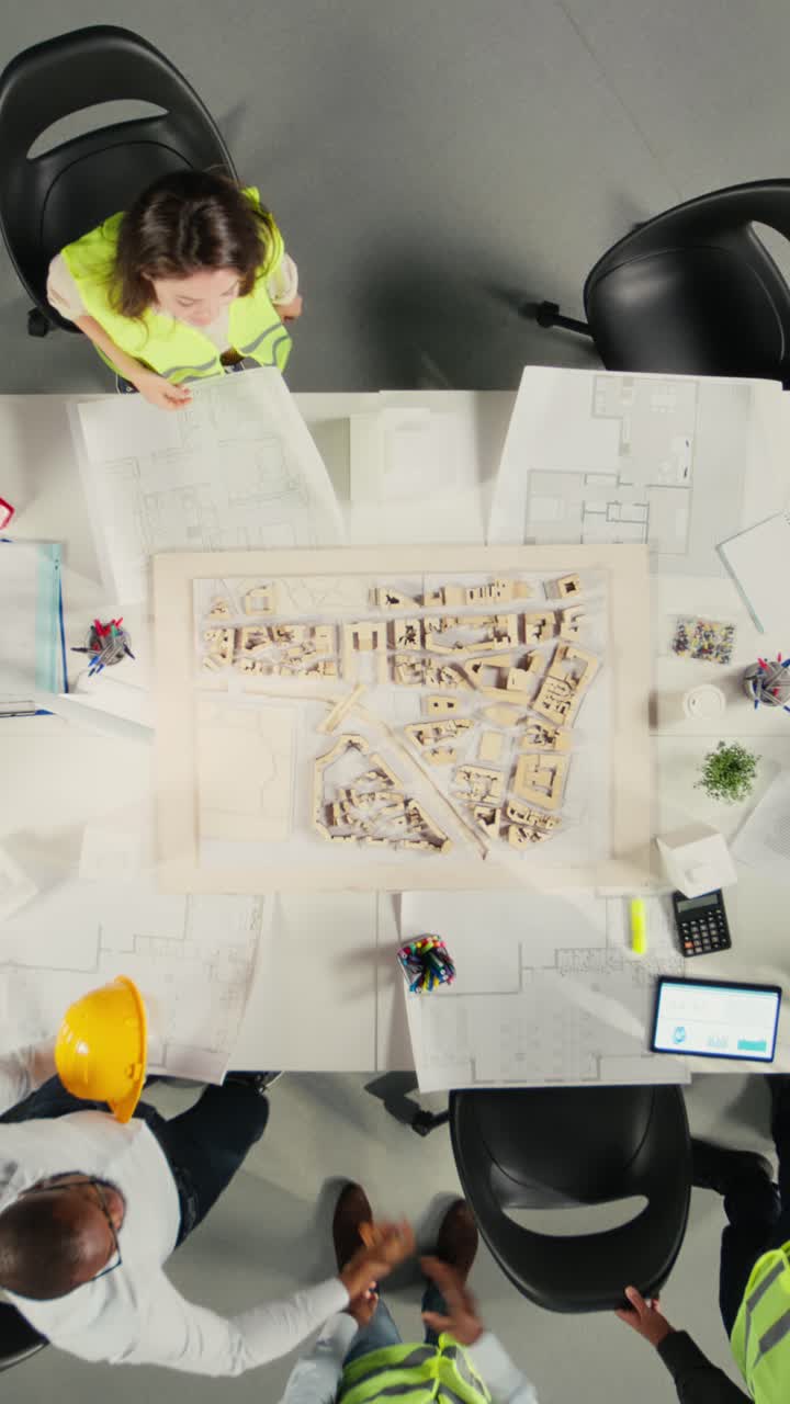 Vertical Video Top down view of development team consulting on real estate investment