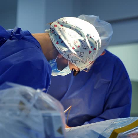 doctor and assistant conduct a surgery. medical specialists working with surgical tools in clinic. surgeon performing professional operation in operating medical room