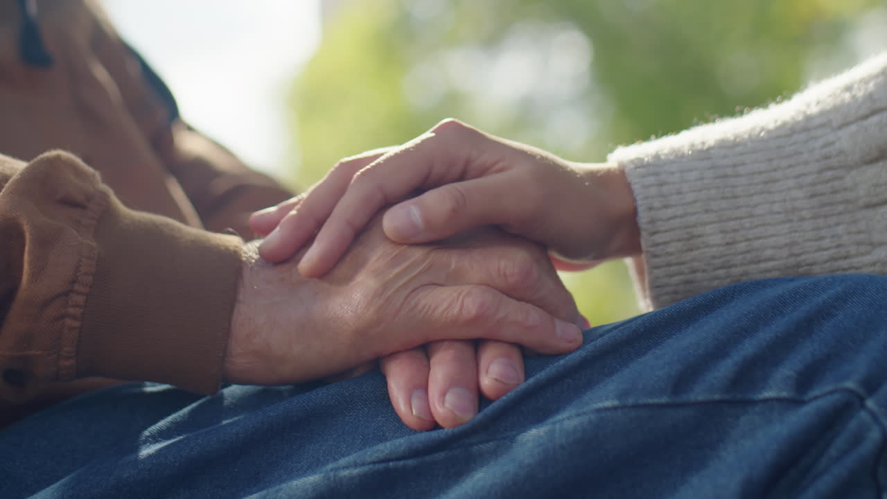 Holding Hands of Elderly Man in Wheelchair