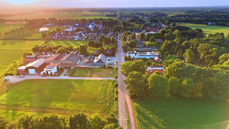 scenic view of the picturesque rural area. drone footage over the straight road passing the village with lush greenery