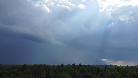 zdjęcie drona z powietrza promieni słonecznych świecących przez gęste dramatyczne chmury burzowe budujące się w atmosferze nad lasem w muskoka w kanadzie