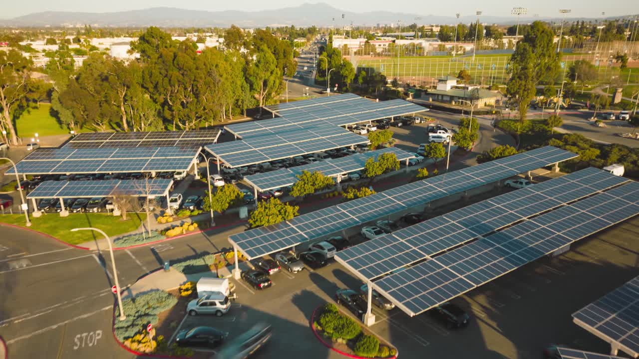 Explore the innovative green energy solution at this parking lot with its rooftop solar panels and lush green trees in this stunning drone time-lapse, showcasing clean energy