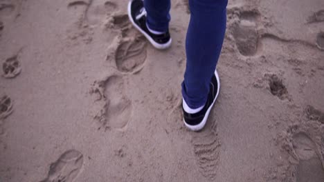 Tracking-slow-motion-shot-of-someone-leaving-footprints-in-the-sand