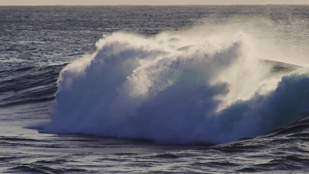 Ocean wave cresting and rolling with dynamic energy, coastal nature in slow motion, natural backdrop background erupting with whitewash