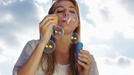 Beautiful-woman-blowing-bubbles-outdoors-sunshine-freedom-blue-sky-is-pretty