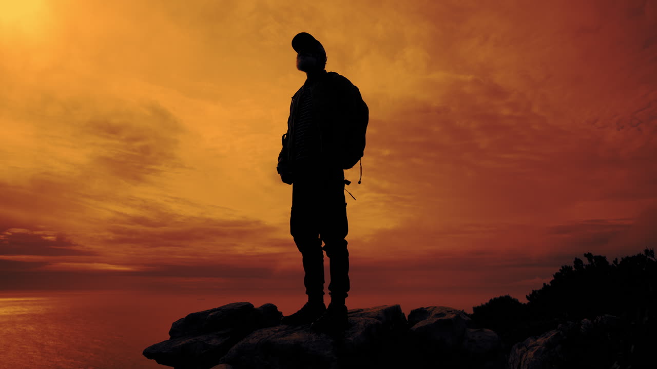 Silhouette of a man with a backpack at sunset