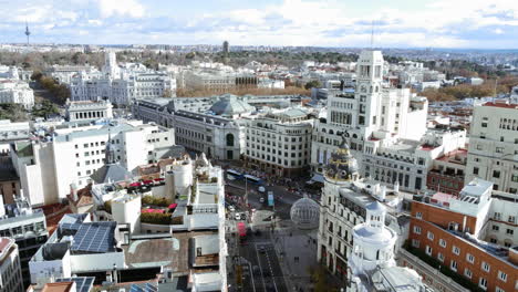 aerial panorama of madrid, spain. cityscape with metropolis building, bank of spain and cibeles square. copter flying from gran via to alcala street