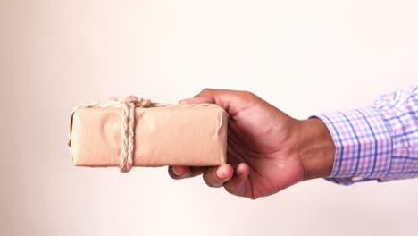 hand giving a wrapped gift box