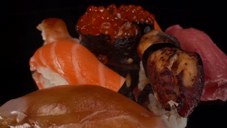 macro view turning nigiri sushi selection on black reflective glass background, toro tuna, salmon, lemon fish and bbq eel, japanese cuisine seafood 4k shot