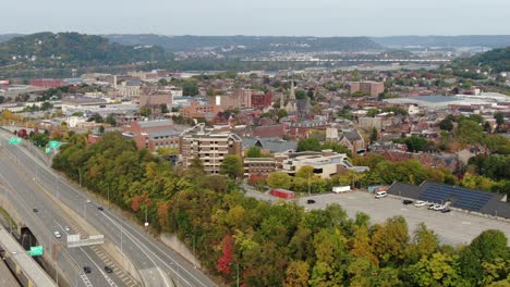 Aerial-pan-of-Pittsburgh-PA-USA-neighborhood,-Route-65,-Chateau,-Manchester,-Old-Allegheny-Rows-Historic-District,-autumn-fall-foliage-dots-skyline