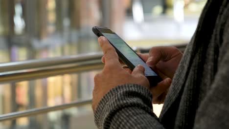 person texting on smartphone in a mall