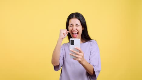 excited woman celebrating success with smartphone