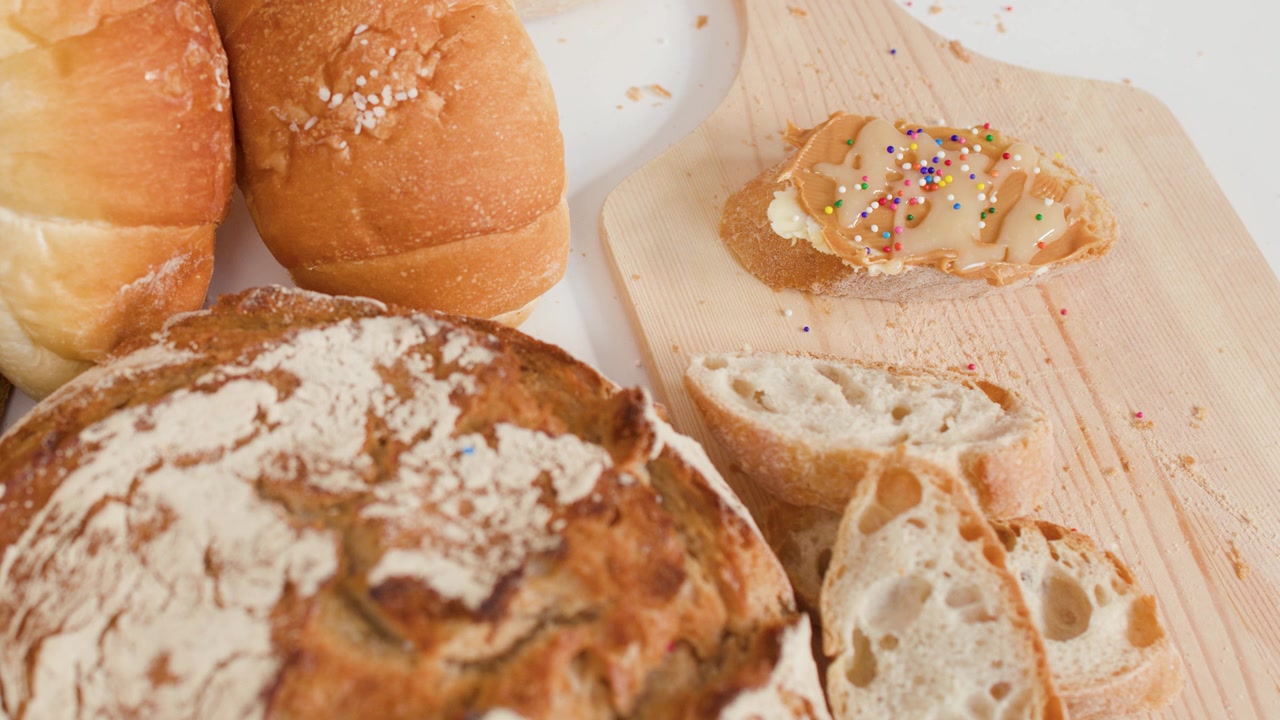 High angle shot of sourdough, croissants, and peanut butter toast with colorful sprinkles.