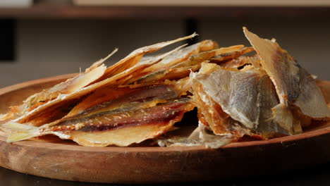 dried fish snacks on wooden plate