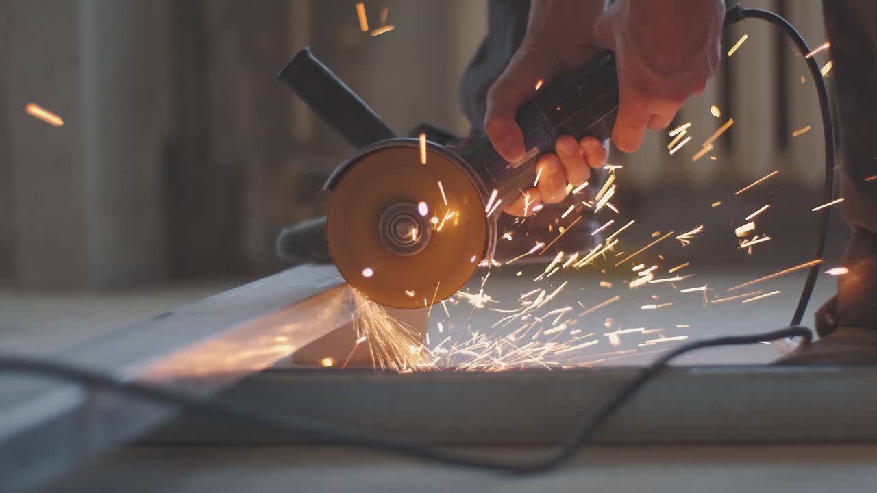 hombre trabaja sierra circular. chispas vuelan de metal caliente. hombre trabajó duro sobre el acero. primer plano en cámara lenta en el garaje