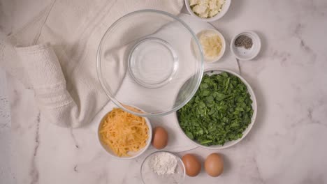 adding spinach to a glass bowl