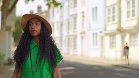 una turista femenina de vacaciones en oxford, reino unido, explorando la ciudad caminando por la calle holywell hacia la cámara.