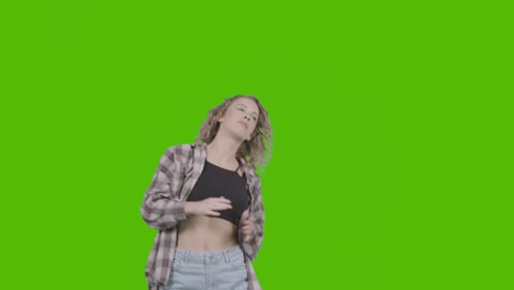 studio shot of young woman having fun dancing against green screen 6