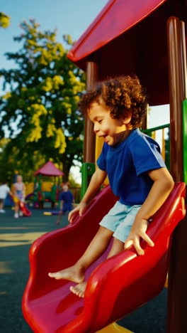 happy boy playing on a slide at a playground