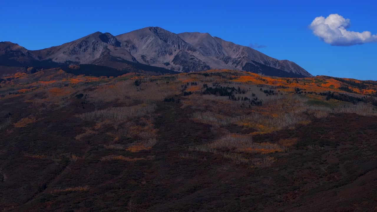 Mount Sopris mountain valley peak from Aspen Old Snowmass Village aerial drone Colorado fall autumn El Jebel Basalt panorama landscape foliage aspen trees forest blue sky cloud circle right motion