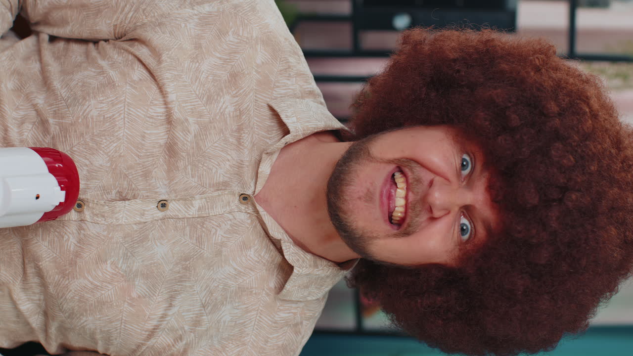 Young caucasian man talking with megaphone, proclaiming news, loudly announcing advertisement