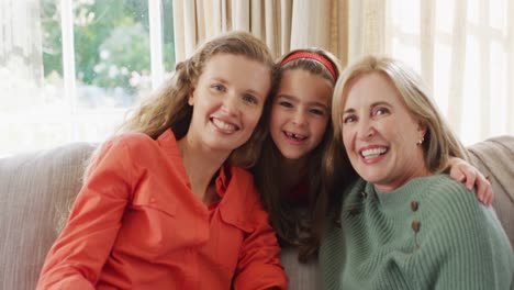 video portrait of happy caucasian mother, grandmother and granddaughter on couch