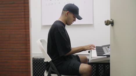 Slow-push-in-shot-revealing-a-piano-student-playing-music-alone-in-a-studio