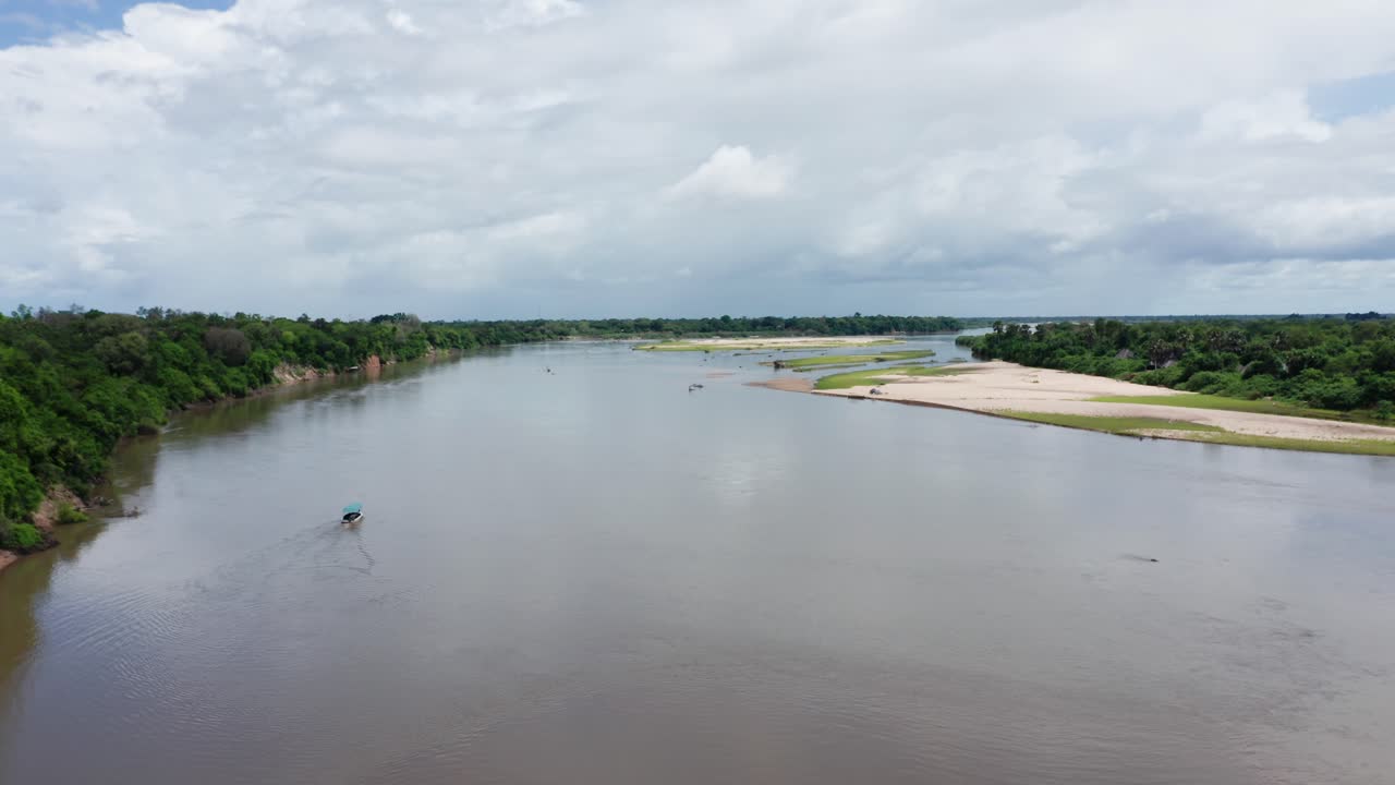 Aerial drone shot flying forward over a river in Selous, Tanzania. Cloudy sky