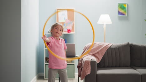 niño diligentemente hula-hooping en una habitación luminosa donde hay un cuaderno