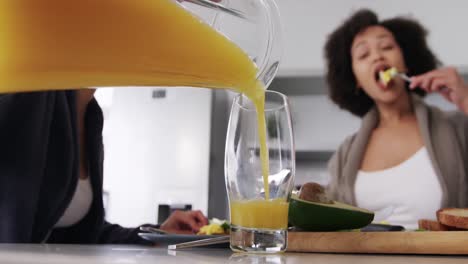 Lesbian-couple-having-breakfast-in-kitchen