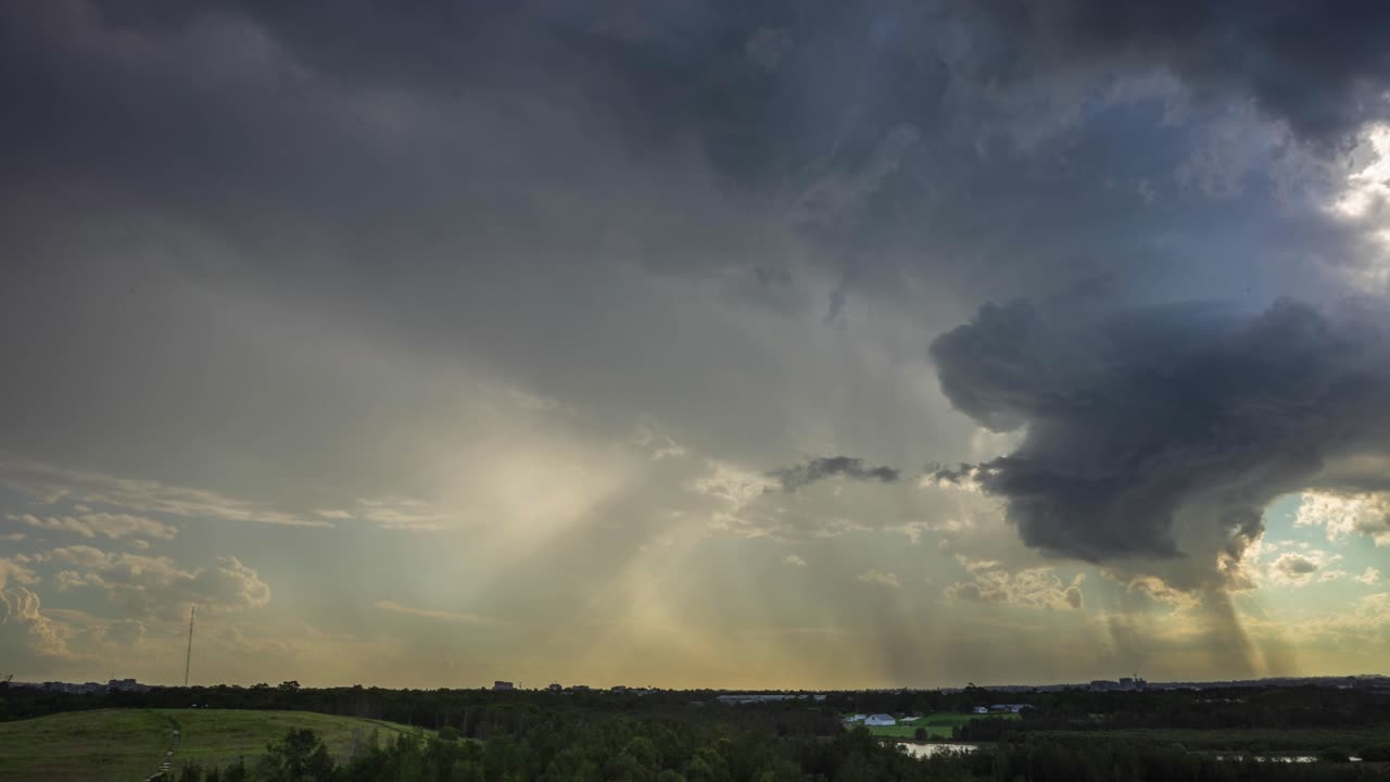 Storm cloud unfolding over western Sydney and Parramatta city. Sunset view from the hill, rain clouds passing with sun rays.