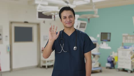 un médico indio feliz saludando a la cámara