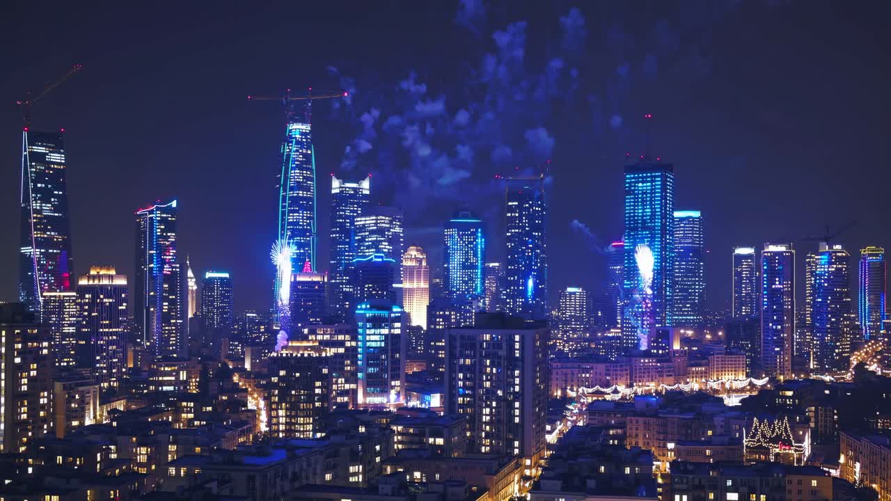 Aerial view of a vibrant city skyline at night, showcasing illuminated skyscrapers