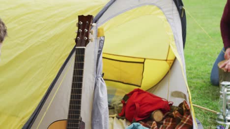 feliz padre caucásico con su hijo preparando el campamento con tienda de campaña en el jardín