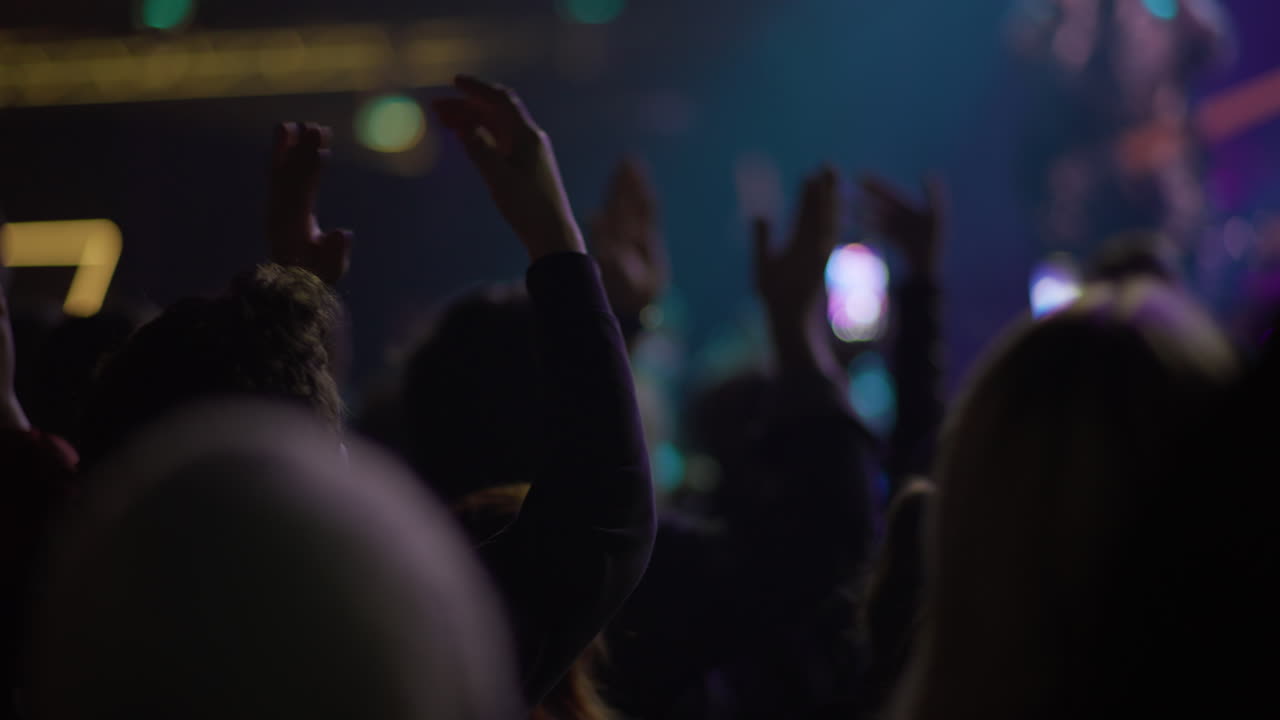 Folla energica che applaude e alza le mani a un concerto di musica dal vivo