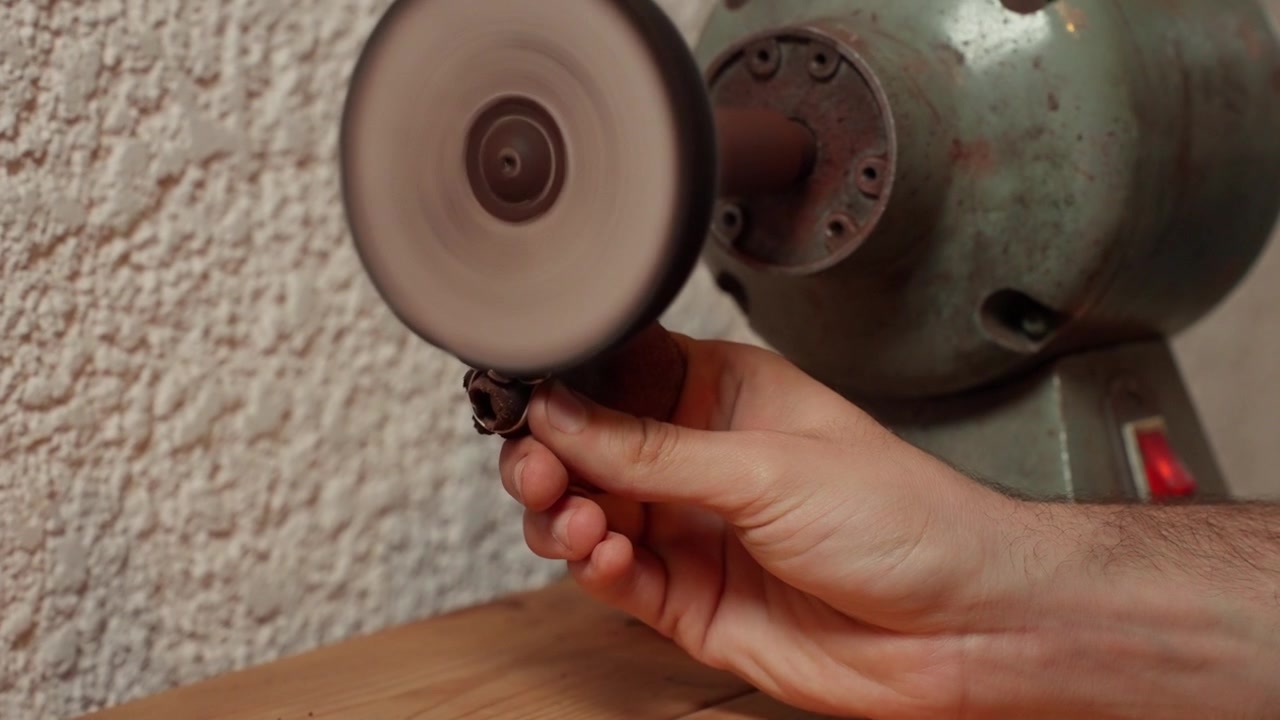 Gioielliere che lavora su un anello in laboratorio, incastonatura e lucidatura.