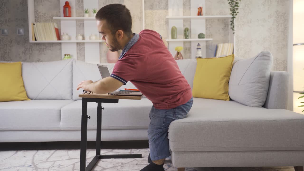 joven estudiante con enanismo estudiando en casa usando una computadora portátil.