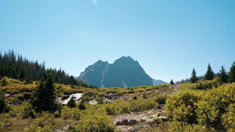 stunning nature landscape view of the incredible red castle peak up a backpacking trail in the high uinta national forest between utah and wyoming with a waterfall and pine trees in the foreground
