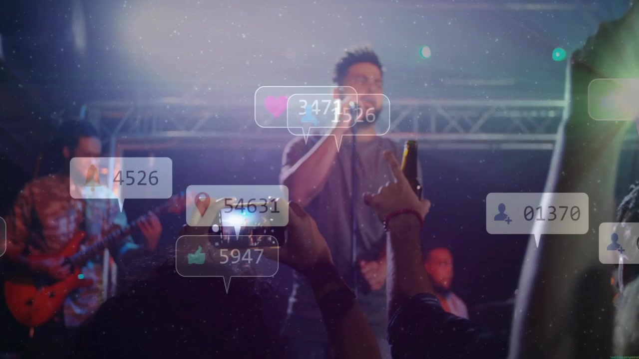 Primeiro celular sendo levantado, vocalista principal cantando, guitarrista tocando, reações crescendo enquanto a multidão grava.