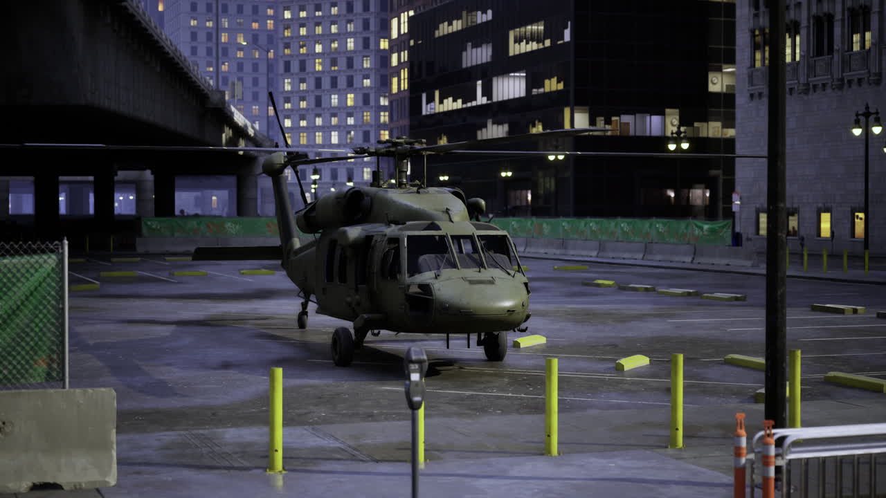 Military helicopter parked in an urban area at night under city lights